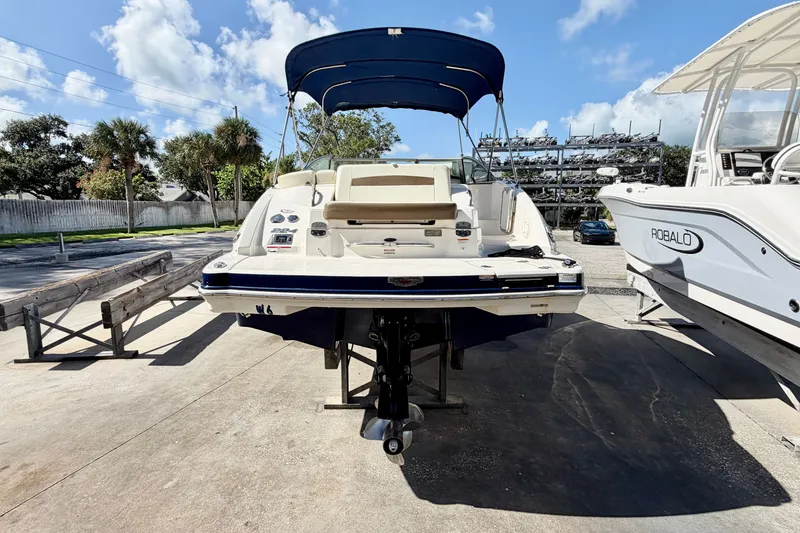 Slide: The Image of 2015 Chaparral 224 Sunesta boat with canopy, parked outdoors under blue sky. - 5