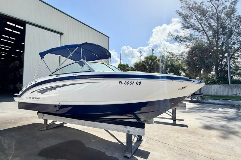 Slide: The Image of 2015 Chaparral 224 Sunesta boat with blue canopy on display outside a warehouse. - 7