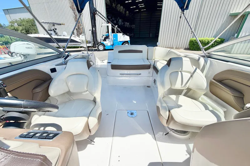 Slide: The Image of 2015 Chaparral 224 Sunesta boat interior with white seating and steering wheel. - 8