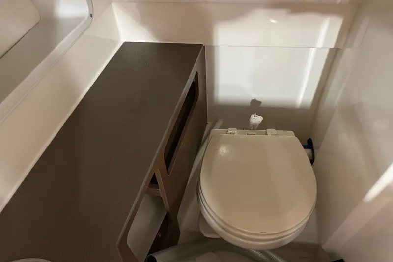 Slide: The Image of 2015 Sea Ray SDX 270 boat bathroom with toilet and storage area. - 15