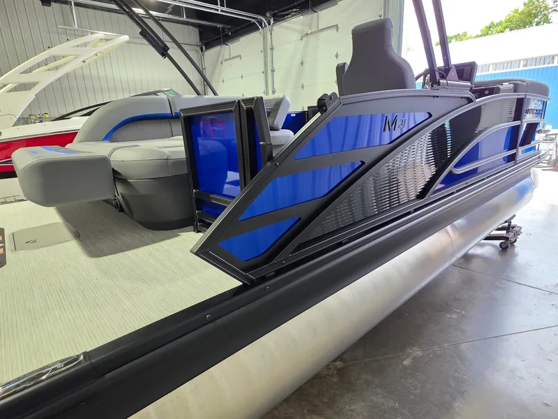 Slide: The Image of A modern pontoon boat with blue accents and comfortable seating in a showroom. - 5