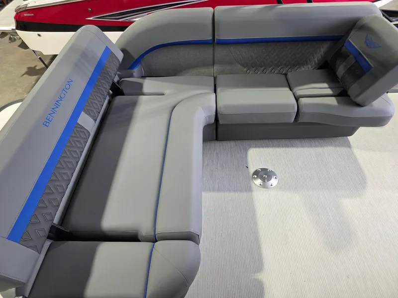 Slide: The Image of The boat features gray upholstered seating with blue accents and the Bennington logo. - 12