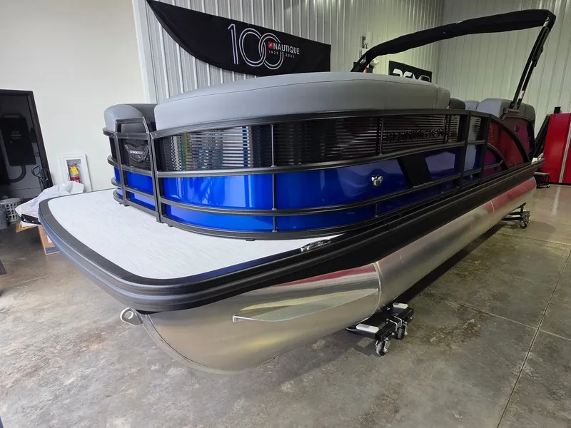 Slide: The Image of A modern 2027 Bennington 21ML SPS TRI pontoon boat with a blue hull and gray seating. - 2