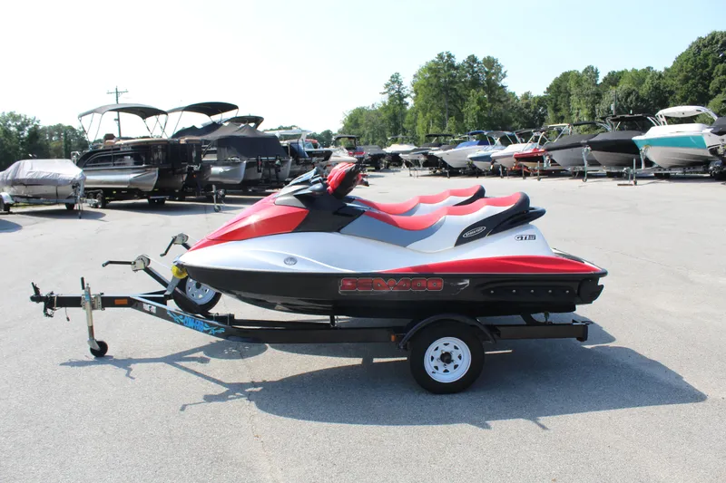 The Image of A red and white 2008 Sea-Doo GTI SE 155 jet ski on a trailer in a parking lot. - 1