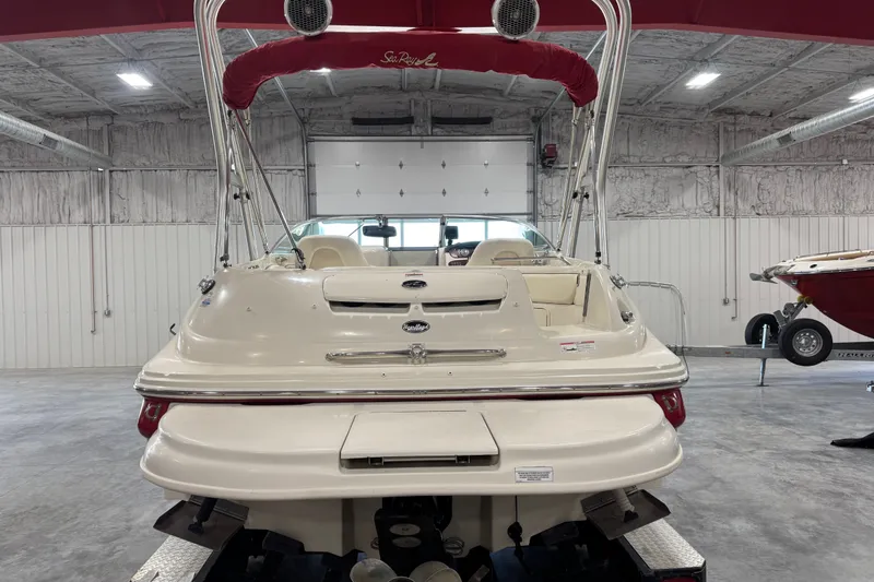 Slide: The Image of 2008 Sea Ray 240 Sundeck boat in a garage, rear view with red canopy. - 5