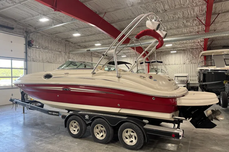 Slide: The Image of 2008 Sea Ray 240 Sundeck boat in a garage, red and white exterior, on a trailer. - 3