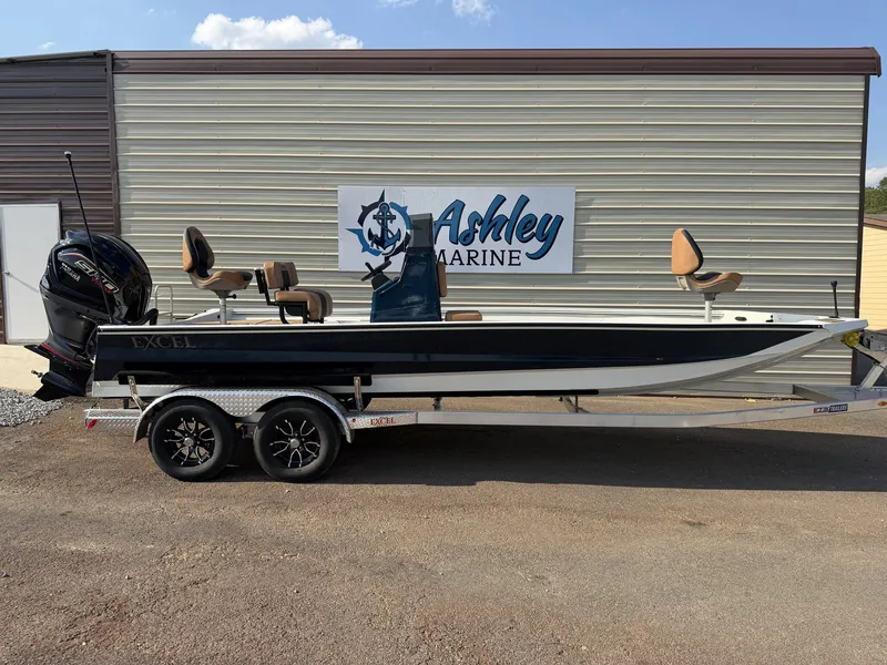 The Image of An Excel Bay Pro Elite 230 ELITE-250SHO-SEADECK boat on a trailer in front of a building. - 1