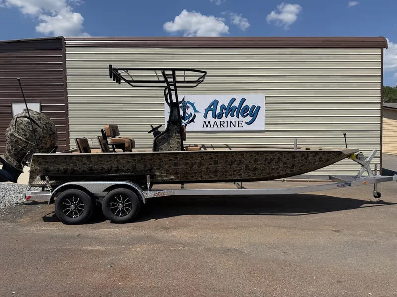 The Image of An Excel Boats Bay Pro Elite 230 on a trailer in front of a building. - 1