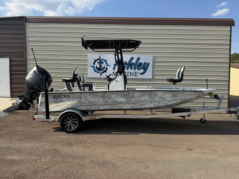 The Image of An Excel Bay Pro 203 boat with a 200HP engine on a trailer in front of a building. - 1