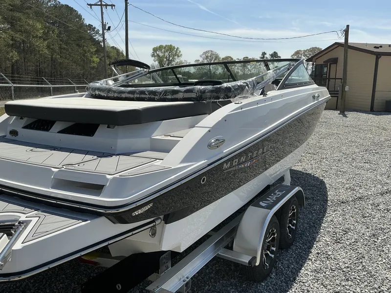 Slide: The Image of A 2025 Monterey M-22 boat on a trailer in a gravel lot. - 13