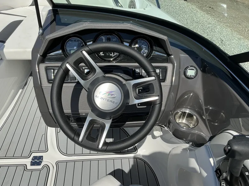 Slide: The Image of The image shows the cockpit of a 2025 Monterey 224FS boat with a modern steering wheel and dashboard. - 17