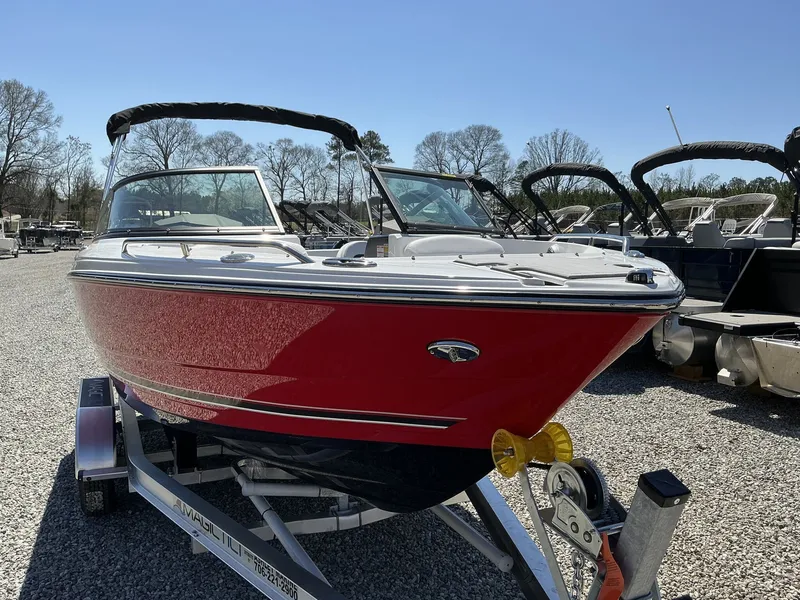 Slide: The Image of A red 2025 Monterey 224FS boat sits on a trailer in a gravel lot. - 4
