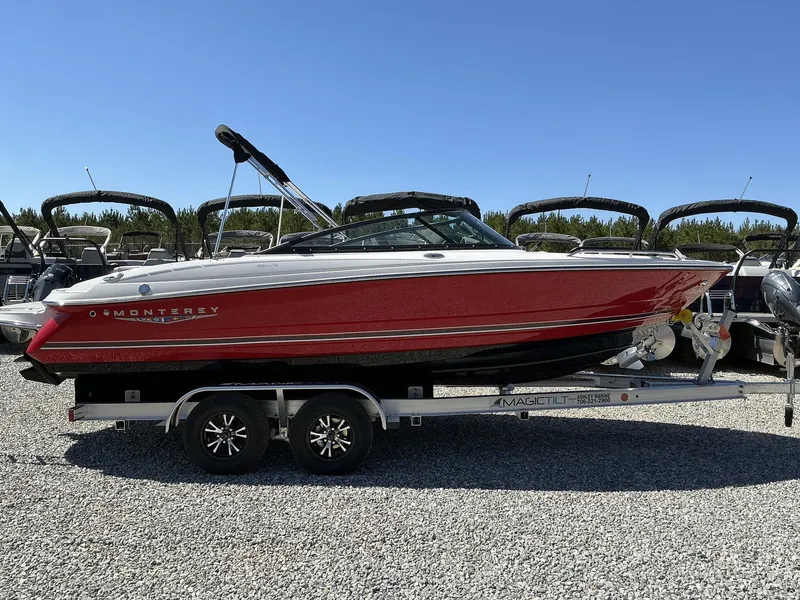 The Image of A red 2025 Monterey 224FS boat is on a trailer in a gravel lot. - 1