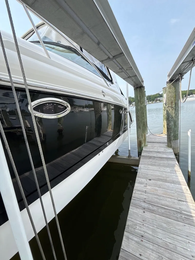 The Image of A 2007 Chaparral Signature 350 docked at a wooden pier. The water is calm. - 0