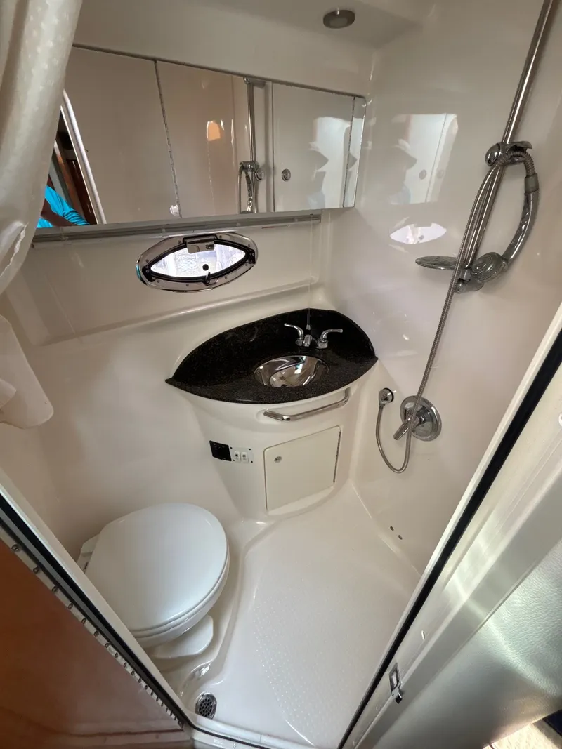 Slide: The Image of The image shows a boat bathroom with a toilet, sink, and shower. - 23