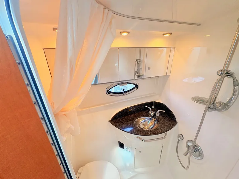 Slide: The Image of The image shows a sleek yacht bathroom with a sink, mirrors, and a shower. - 22