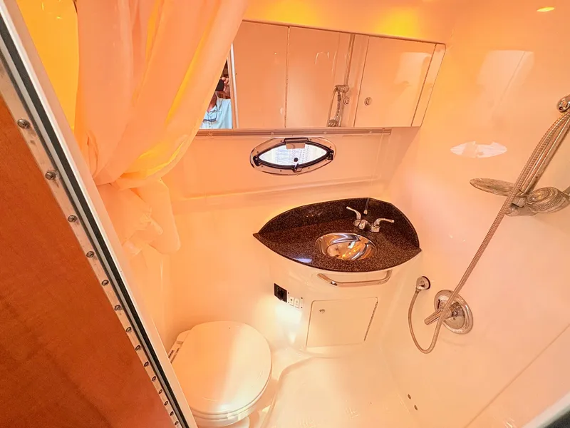 Slide: The Image of The image shows an elegant yacht bathroom with a sink, toilet, and shower. - 24