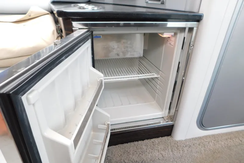 Slide: The Image of Open mini fridge inside 2012 Formula 350 Sun Sport boat, featuring a sleek interior design. - 49