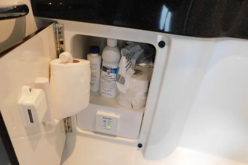 Slide: The Image of Storage compartment in a 2012 Formula 350 Sun Sport boat with cleaning supplies and toilet paper. - 74