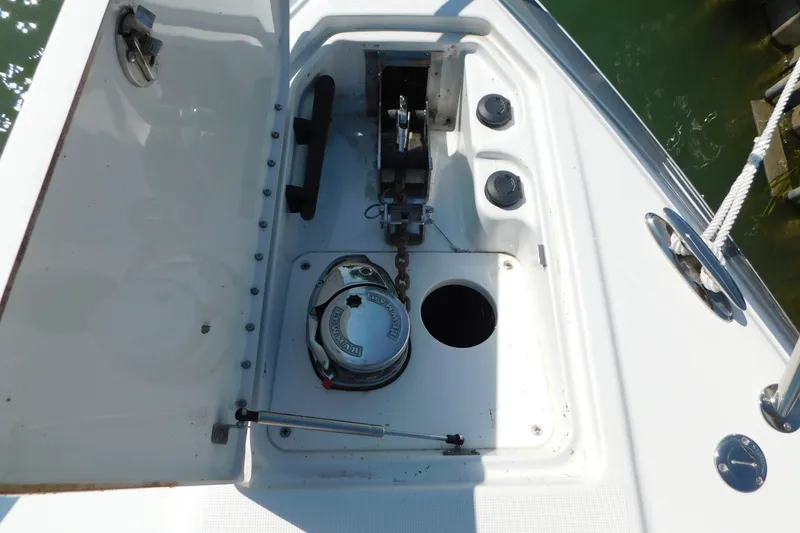 Slide: The Image of Anchor compartment of 2012 Formula 350 Sun Sport boat, featuring a windlass and chain storage. - 97