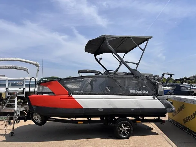 Slide: The Image of A 2022 Sea-Doo Switch Sport 18 with red and gray design, parked on a trailer. - 2