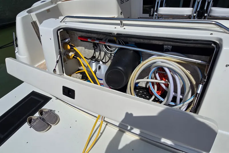 Slide: The Image of Storage compartment on a 2000 Sea Ray 400 Sedan Bridge with hoses and equipment. - 20