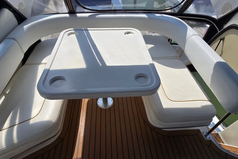 Slide: The Image of Interior seating area of 2000 Sea Ray 400 Sedan Bridge with table and cushioned seats. - 14