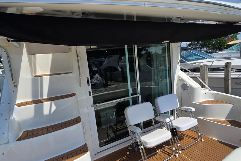 Slide: The Image of 2000 Sea Ray 400 Sedan Bridge yacht deck with chairs and sliding glass door. - 18