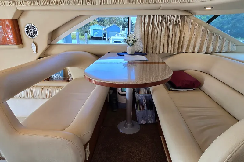 Slide: The Image of Luxurious interior of 2000 Sea Ray 400 Sedan Bridge with elegant seating and table. - 42