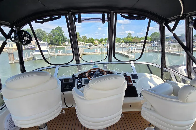 Slide: The Image of Interior view of 2000 Sea Ray 400 Sedan Bridge yacht cockpit with marina backdrop. - 15