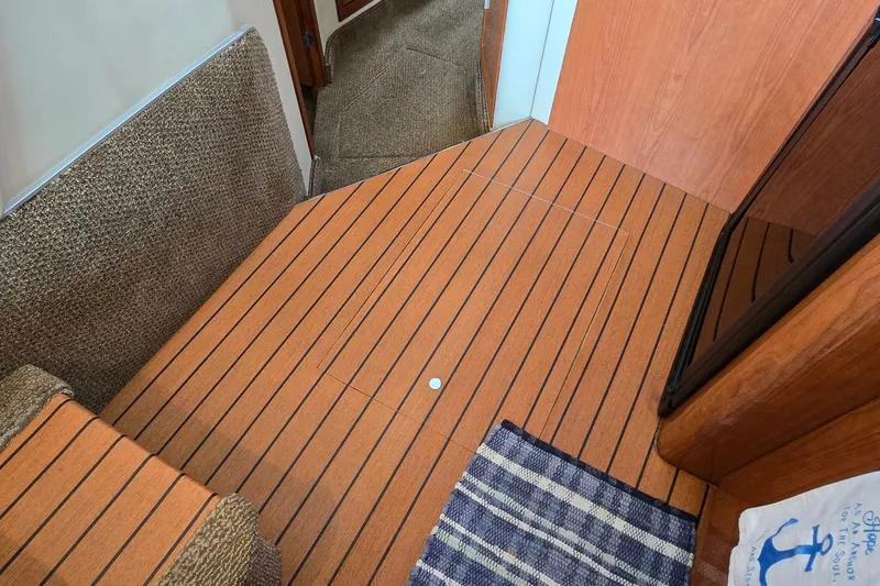 Slide: The Image of Interior of 2000 Sea Ray 400 Sedan Bridge with wood flooring and carpeted steps. - 31