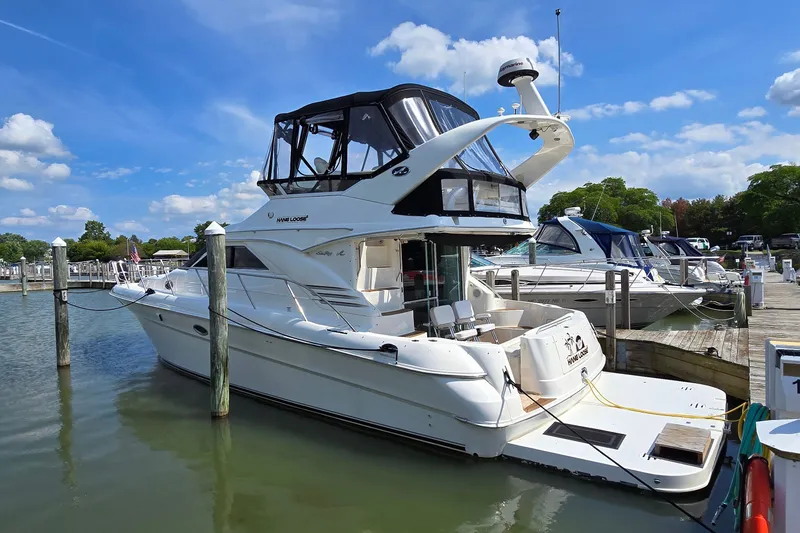 Slide: The Image of 2000 Sea Ray 400 Sedan Bridge yacht docked at marina under blue sky. - 2