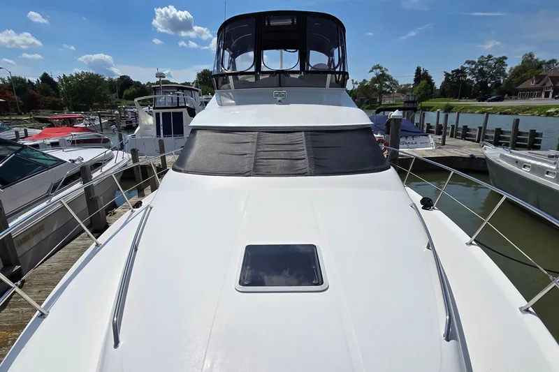 Slide: The Image of 2000 Sea Ray 400 Sedan Bridge yacht docked at marina under clear blue sky. - 6