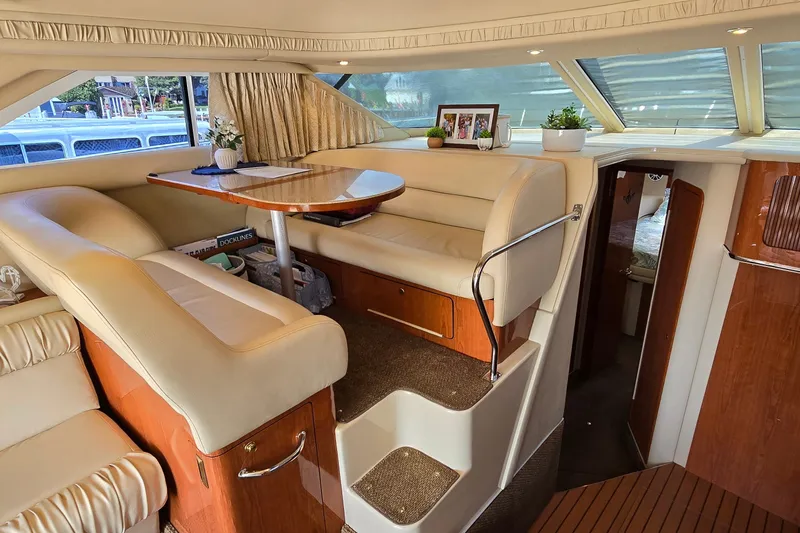 Slide: The Image of Interior of 2000 Sea Ray 400 Sedan Bridge with dining area and cozy seating. - 25