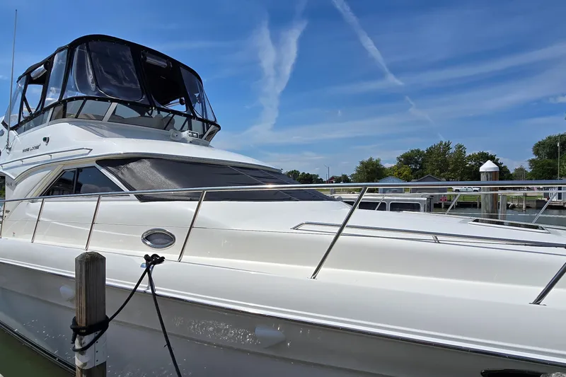 Slide: The Image of 2000 Sea Ray 400 Sedan Bridge yacht docked under clear blue sky. - 5