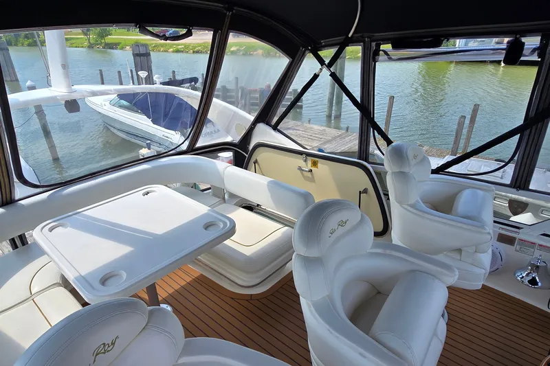 Slide: The Image of Luxurious interior of 2000 Sea Ray 400 Sedan Bridge yacht with white seating and table. - 12