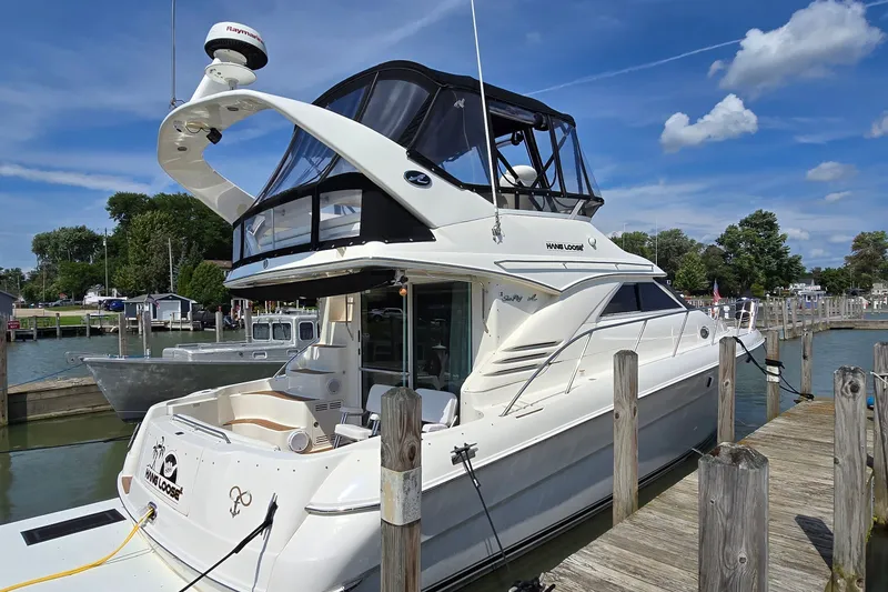 Slide: The Image of 2000 Sea Ray 400 Sedan Bridge yacht docked at marina under blue sky. - 4