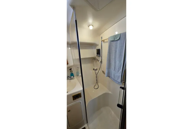 Slide: The Image of Bathroom interior of 2000 Sea Ray 400 Sedan Bridge yacht, featuring shower and towel rack. - 33