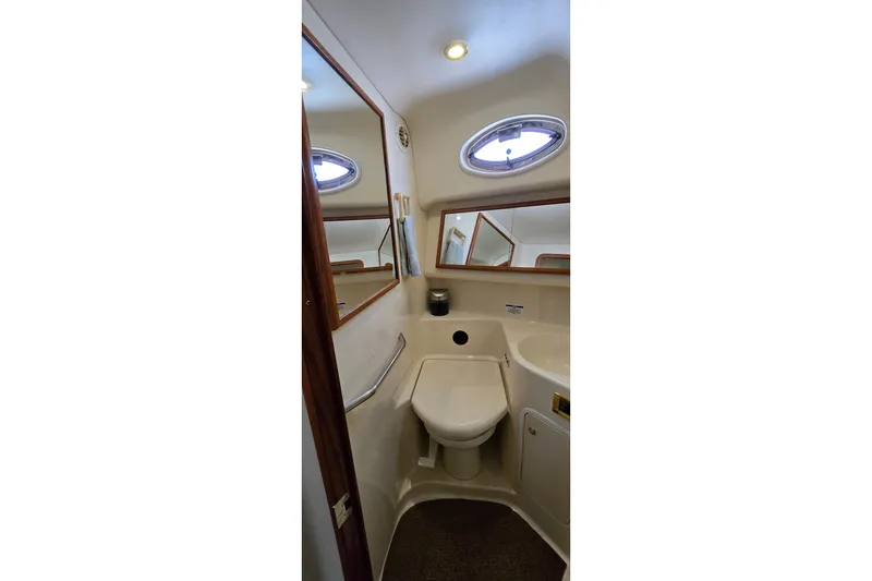 Slide: The Image of Bathroom interior of 2000 Sea Ray 400 Sedan Bridge yacht, featuring mirror and porthole window. - 34