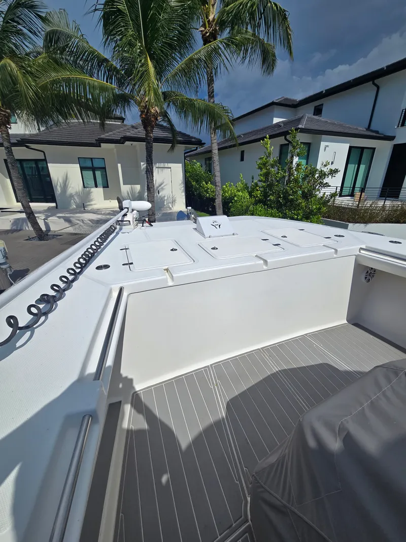 Slide: The Image of The image shows the deck of a 2023 Hammer Yachts 35 Cat. It's spacious and modern, with palm trees in the background. - 7
