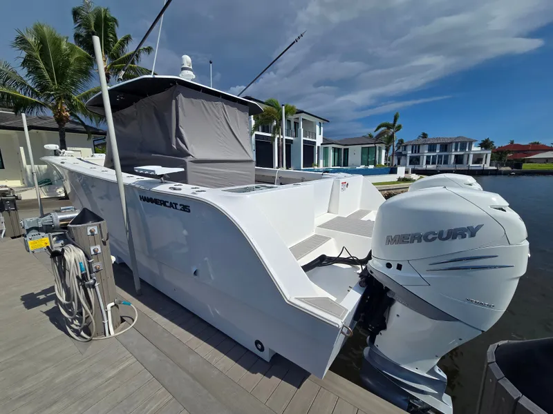 Slide: The Image of A modern 2023 Hammer Yachts 35 Cat is docked. It features a Mercury outboard motor, surrounded by palm trees and modern houses. - 4