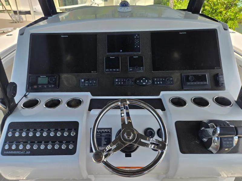 Slide: The Image of The image shows the helm of a 2023 Hammer Yachts 35 Cat with multiple screens and controls. - 15