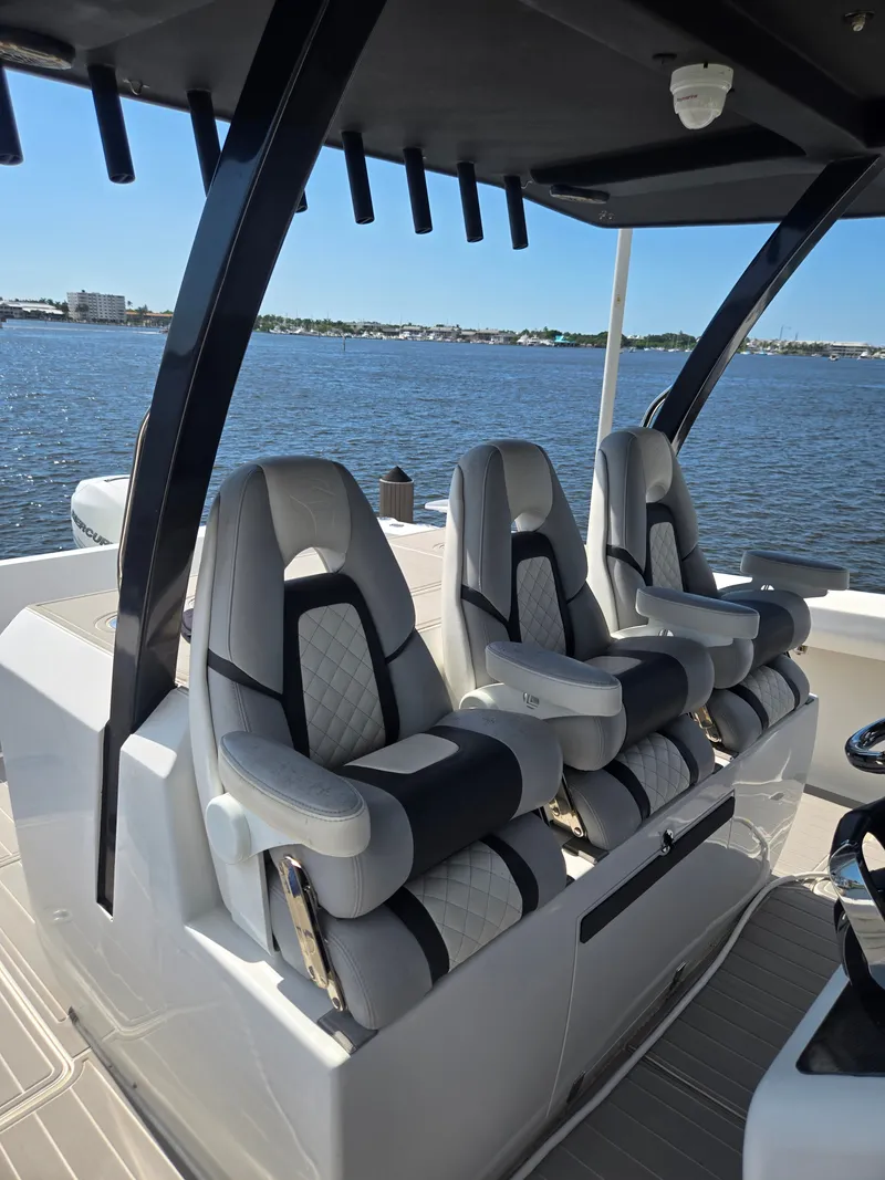 Slide: The Image of Three luxurious, padded seats on a modern boat overlooking the water. - 20