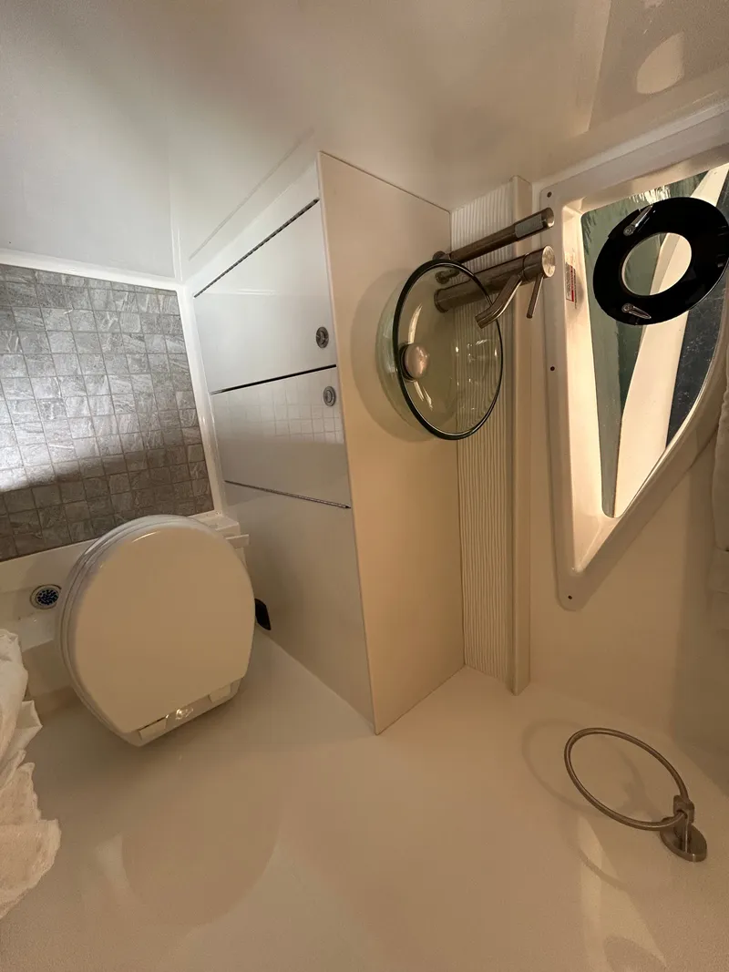 Slide: The Image of The 2023 Sea Ray Sundancer 320 bathroom features a modern design with a glass sink. - 20