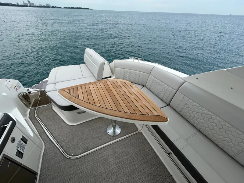 Slide: The Image of The image shows the stern of a Sea Ray Sundancer 320 with elegant seating and a wooden table. - 15