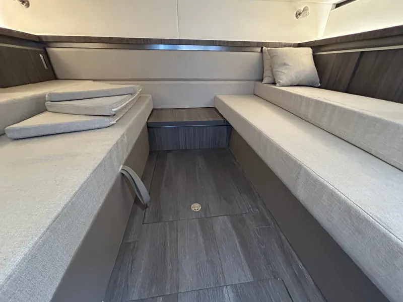 Slide: The Image of Interior of the Sea Ray Sundancer 320 with gray cushions and wood flooring. - 18