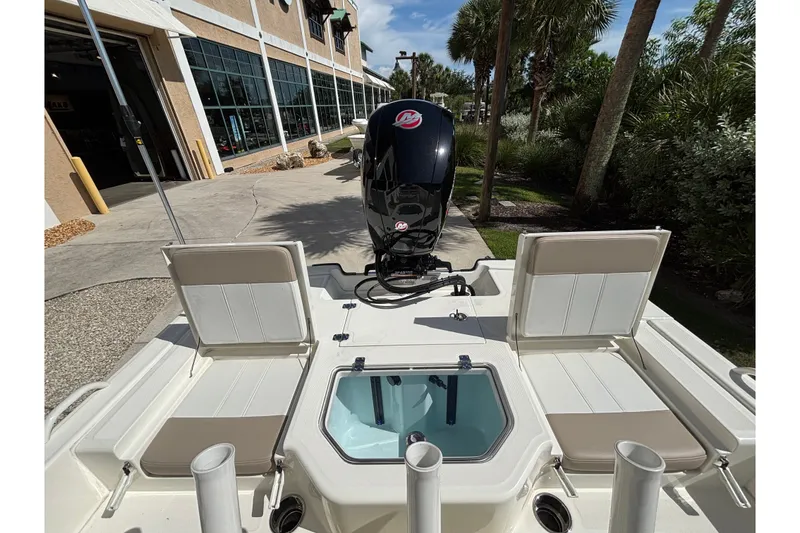 Slide: The Image of 2026 Mako Pro Skiff 19 CC boat with seating and motor, displayed outdoors. - 14