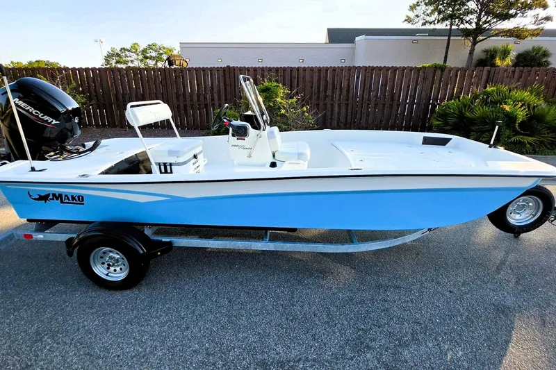 Slide: The Image of 2027 Mako Pro Skiff 17 CC boat on trailer, featuring a sleek blue and white design. - 14