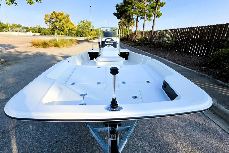 Slide: The Image of 2027 Mako Pro Skiff 17 CC boat on trailer, parked outdoors, showcasing spacious deck. - 15