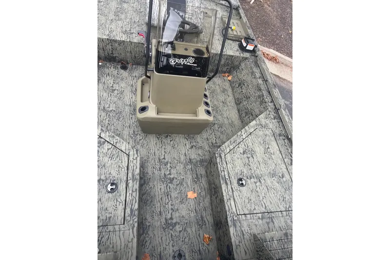 Slide: The Image of 2027 Tracker Grizzly 2072 CC Sportsman boat interior with camouflage design and central console. - 18